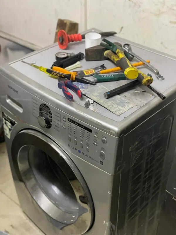 Front-load washing machine with repair tools during a doorstep visit