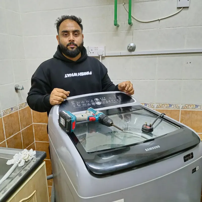 Technician repairing a Samsung top-load washing machine