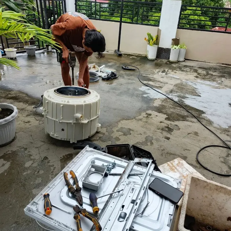 Top-load washing machine tub removed during a repair