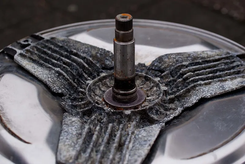 Corroded washing machine drum spider and shaft removed from the drum